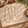 Assorted natural shell leis in different colors and shell styles