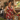 Woman wearing a red Hibiscus Plumeria Hawaiian apron in a warm kitchen setting